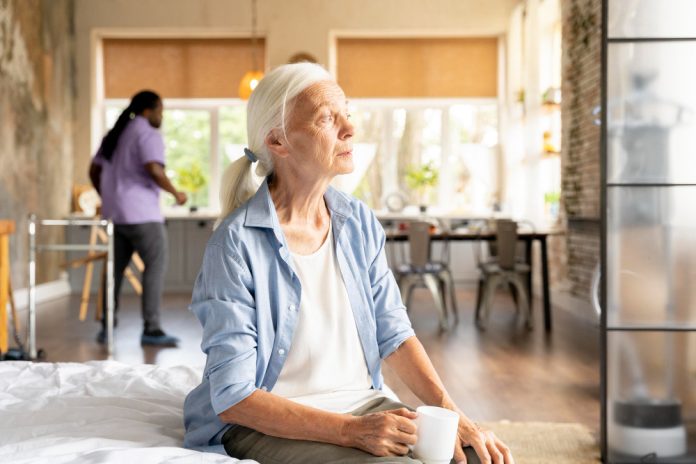 Aide-soignante accompagnant une personne âgée à domicile Auxiliaire de vie aidant une personne âgée, illustrant une alternative à la maison de retraite